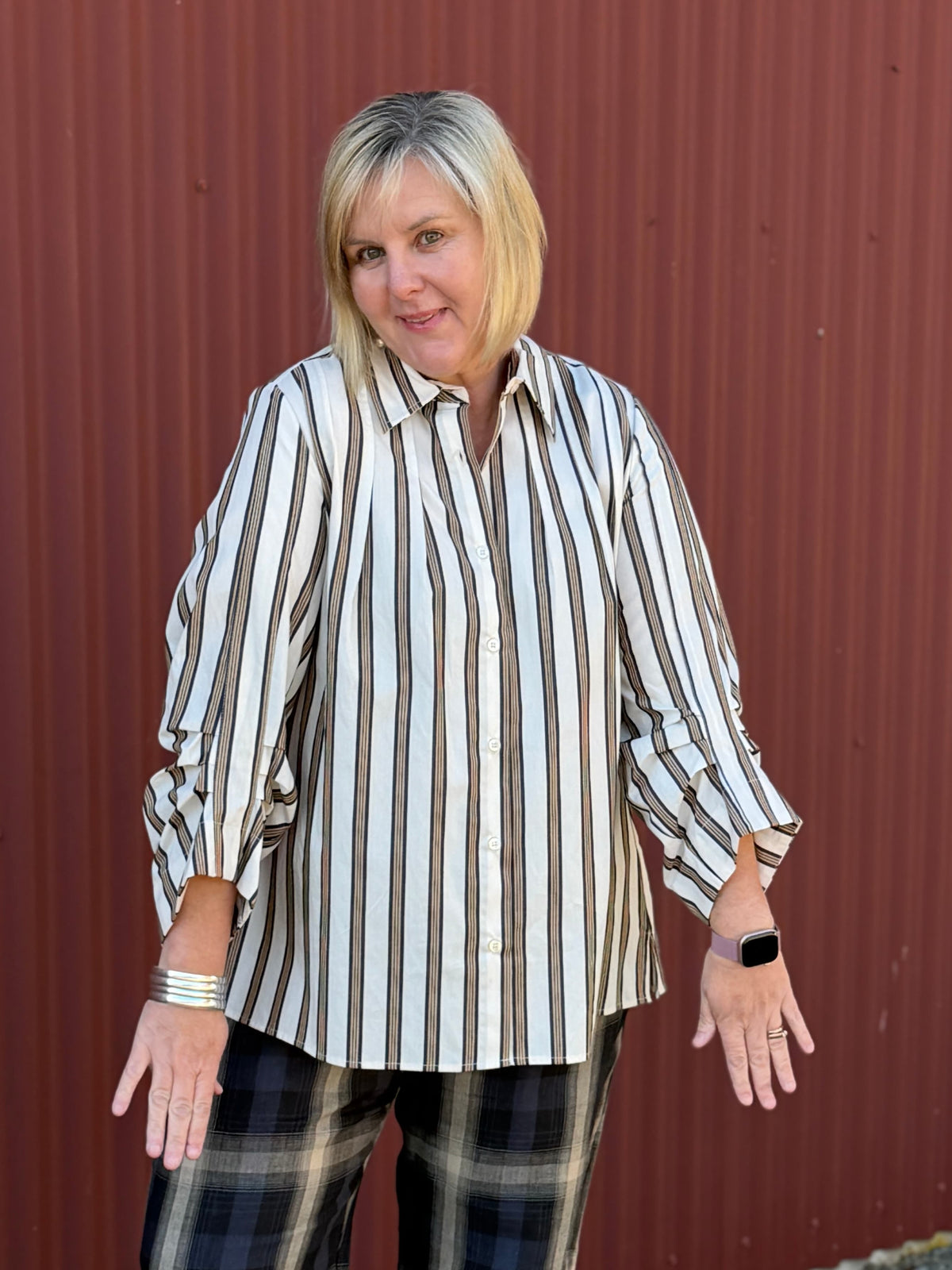 A modern striped cotton shirt by OBI, featuring a relaxed fit, button front, curved hem, longer back and beautifully pleated sleeves.