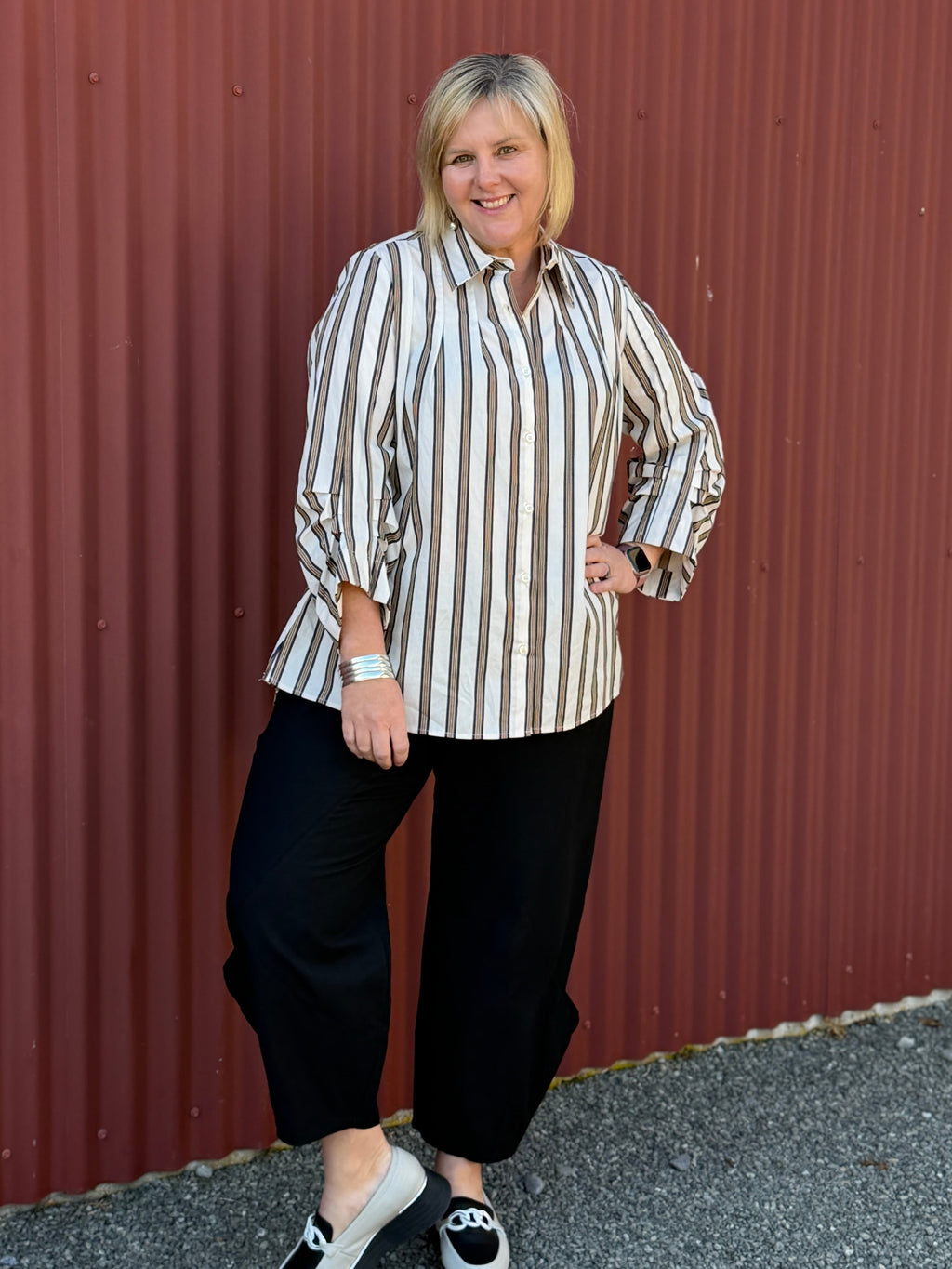 A modern striped cotton shirt by OBI, featuring a relaxed fit, button front, curved hem, longer back and beautifully pleated sleeves.