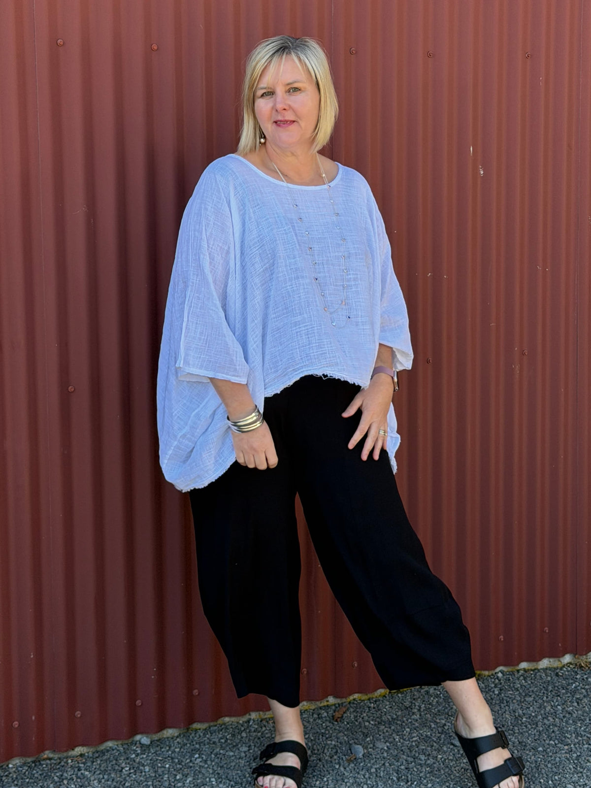 Cotton gauze tunic top. 100% breathable cotton, it's got an oversized fit, wide draped sleeves, and an asymmetrical frayed hem for that relaxed, lived-in vibe. Label: CINDY G