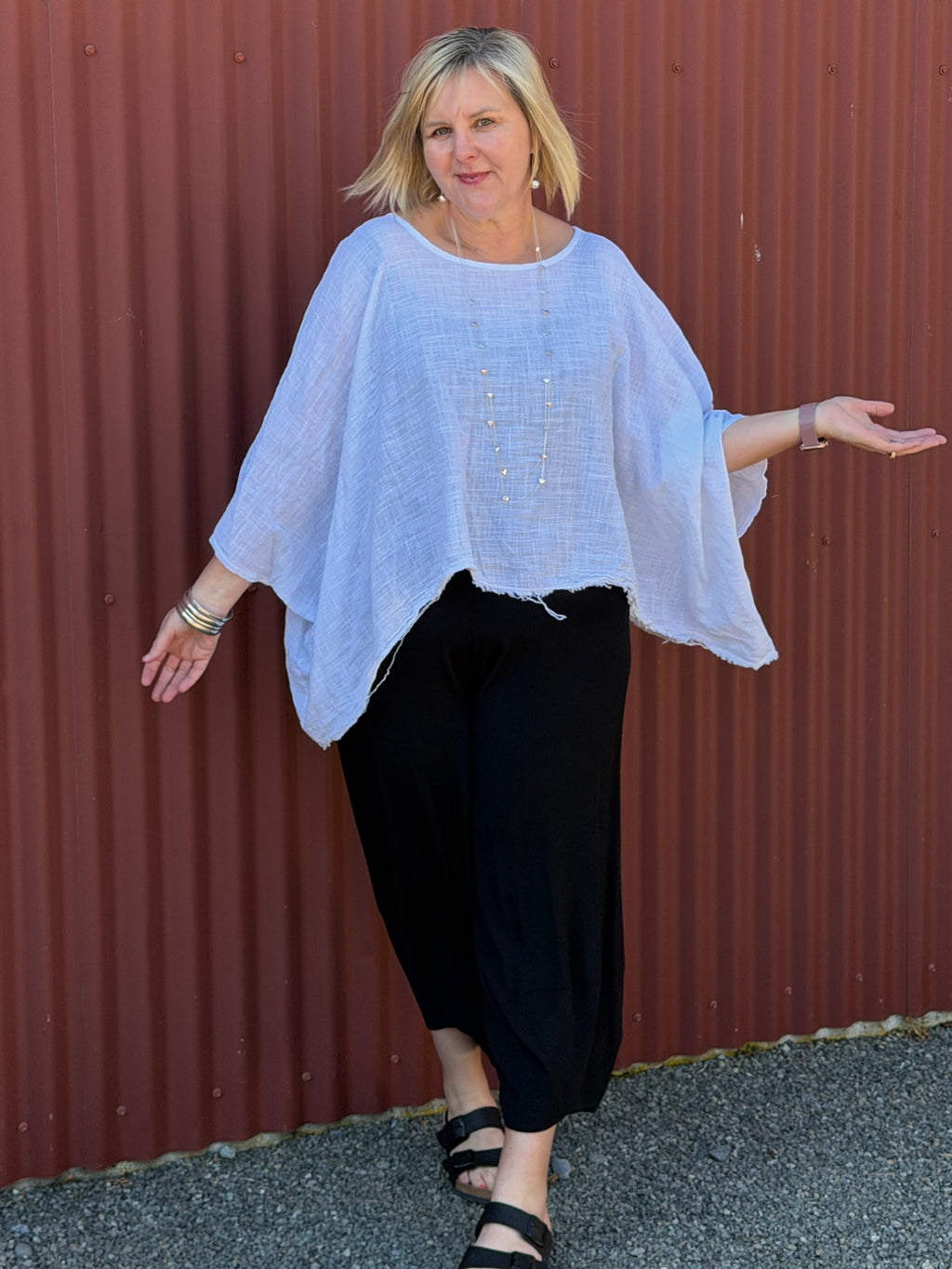 Cotton gauze tunic top. 100% breathable cotton, it's got an oversized fit, wide draped sleeves, and an asymmetrical frayed hem for that relaxed, lived-in vibe. Label: CINDY G