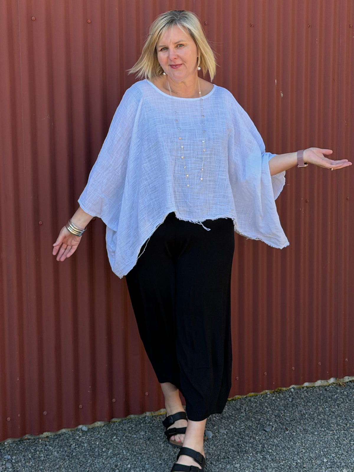 Cotton gauze tunic top. 100% breathable cotton, it's got an oversized fit, wide draped sleeves, and an asymmetrical frayed hem for that relaxed, lived-in vibe. Label: CINDY G