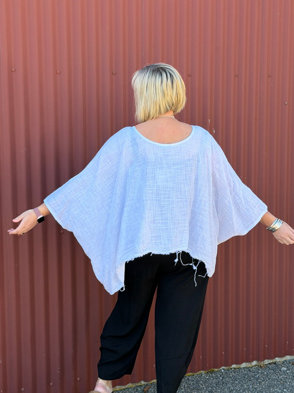 Cotton gauze tunic top. 100% breathable cotton, it's got an oversized fit, wide draped sleeves, and an asymmetrical frayed hem for that relaxed, lived-in vibe. Label: CINDY G