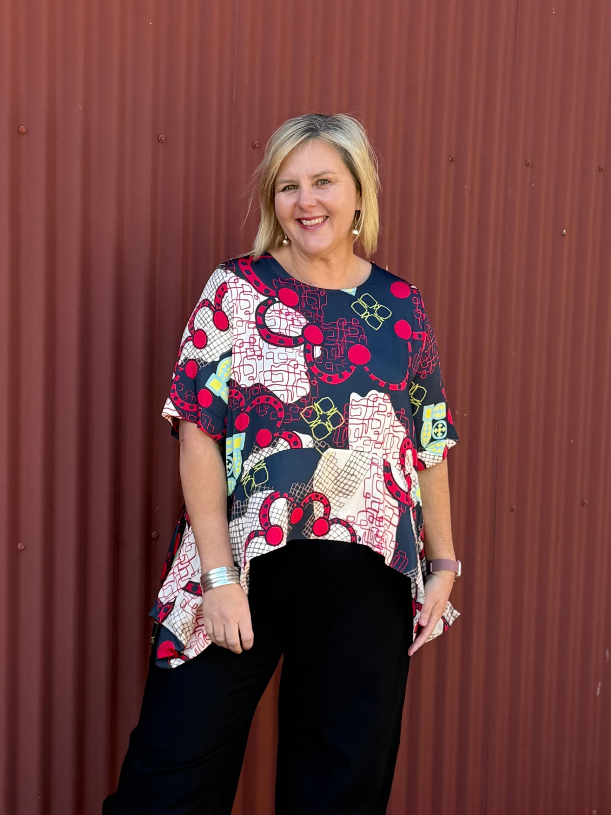 The OBI Marakesh Drape Top features a vibrant print, scoop neckline, elbow-length sleeves and a flowing curved hem. Crafted from 100% viscose for an easy drape.