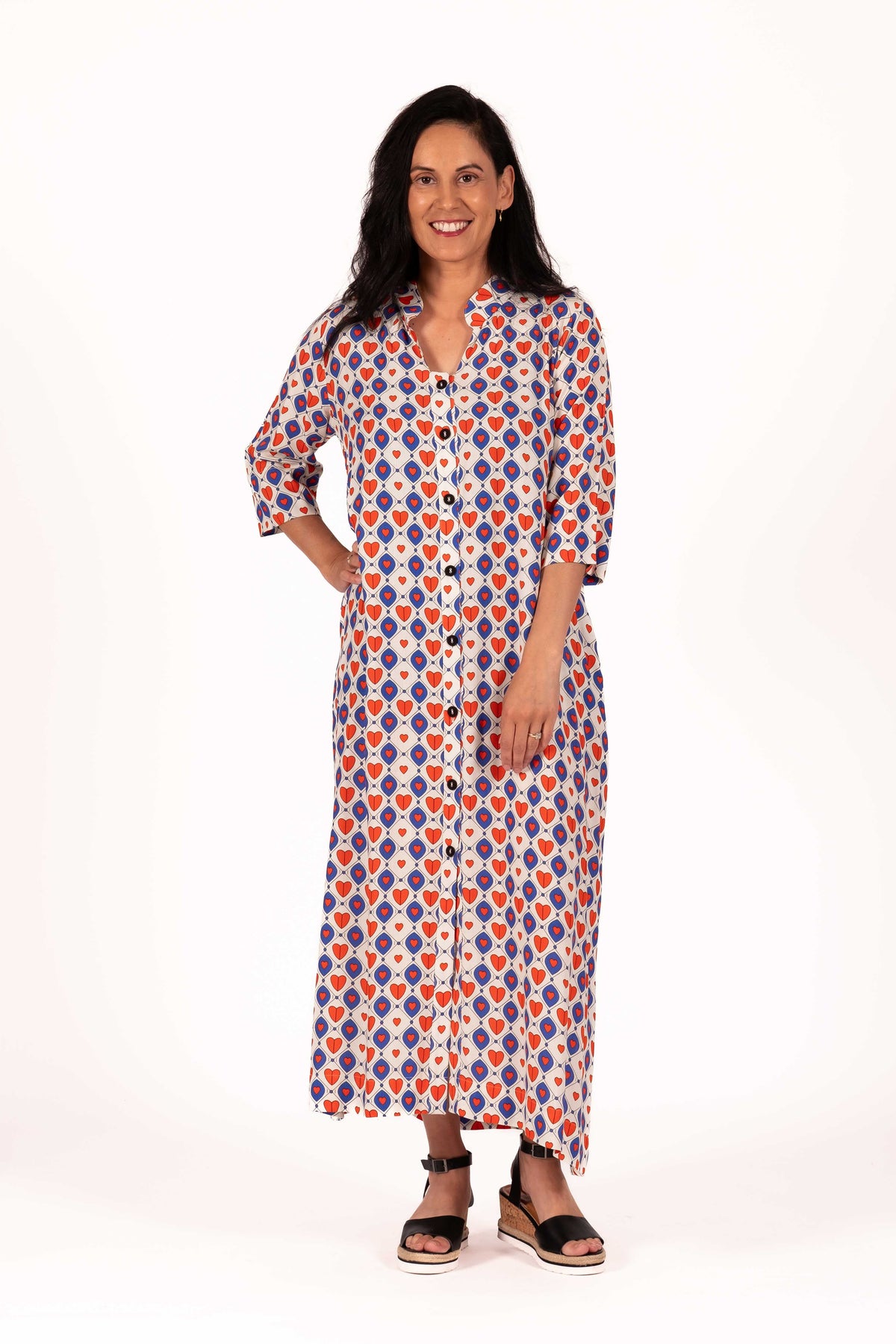 A playful mix of cobalt blue, warm red, and soft cream gives this print a fun retro charm to this dress. The geometric heart pattern creates a bold statement, while the lightweight fabric keeps the look relaxed, floaty, and easy to wear. By Jellicoe