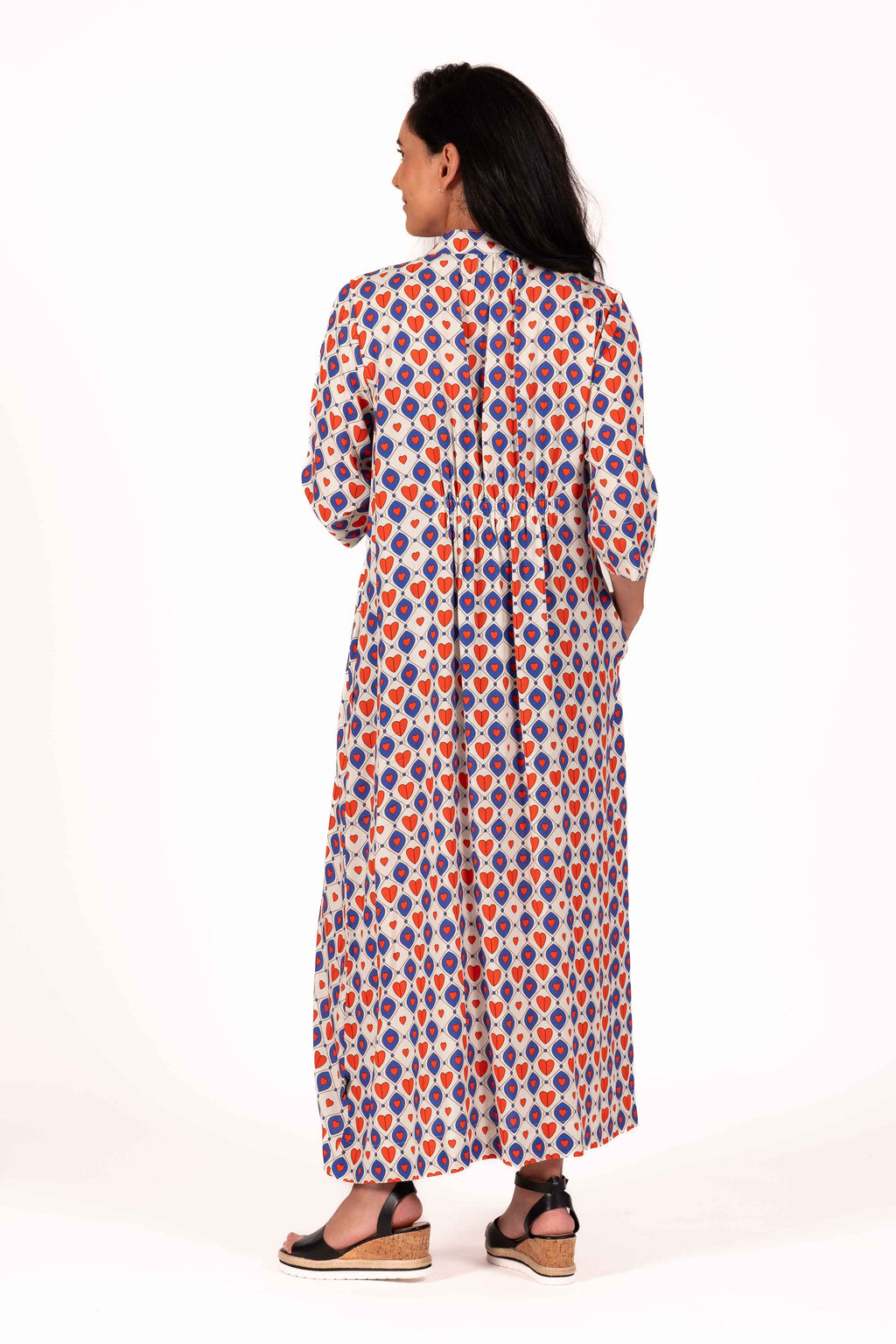 A playful mix of cobalt blue, warm red, and soft cream gives this print a fun retro charm to this dress. The geometric heart pattern creates a bold statement, while the lightweight fabric keeps the look relaxed, floaty, and easy to wear. By Jellicoe