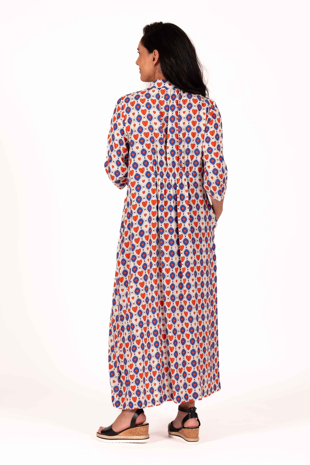 A playful mix of cobalt blue, warm red, and soft cream gives this print a fun retro charm to this dress. The geometric heart pattern creates a bold statement, while the lightweight fabric keeps the look relaxed, floaty, and easy to wear. By Jellicoe