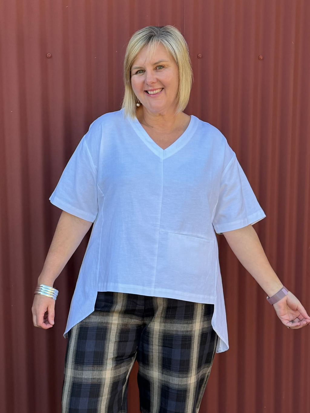The OBI Tussie Mussie Pocket Top features a relaxed drape, flattering V-neck, asymmetric panels, contrast stitching and a longer curved back. Linen cotton blend.